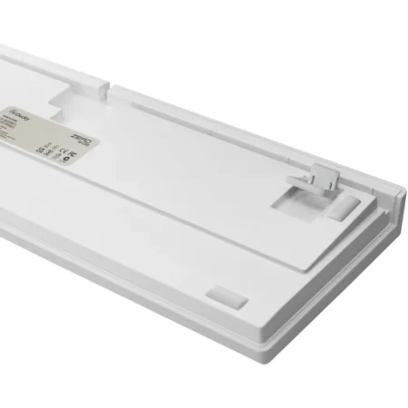 A straight-on side view showing the 3-level adjustable feet structure on the white base of the keyboard.